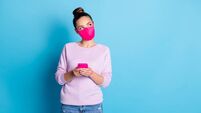 Photo of pretty lady keep social distance people hold telephone hands browsing website think over new post look up wear protect