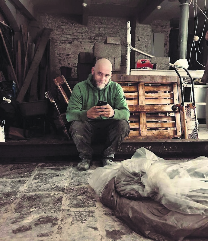 Tom Creedon working on the new premises and (right) adding a lick of paintwork