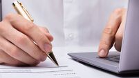 Businessperson's Hand Signing Document With Pen