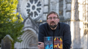 <p> Gareth Hanrahan with two of his books, The Gutter Prayer and the Shadow Saint. He releases The Broken God next week. Picture Dan Linehan</p>