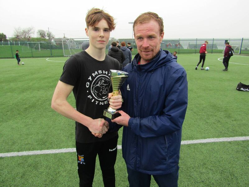 Youghal Charity Soccer Tournament organiser Mossy Clohessy presents the Youghal United Christmas Cup to Be Active team captain Jake O'Brien. 