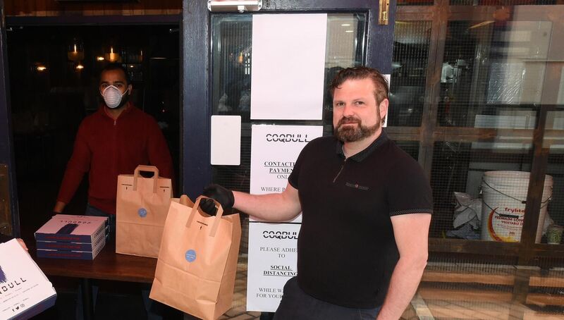 Mike Ryan demonstrating a 'pick up' service from Richard Desousa (behind the protective screen). Pic Larry Cummins Mike Ryan demonstrating a 'pick up' service from Richard Desousa (behind the protective screen). Pic Larry Cummins