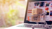 Shopping online concept - Parcel or Paper cartons with a shopping cart logo in a trolley on a laptop keyboard. Shopping service