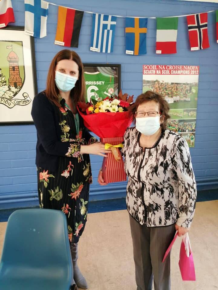 Ina Foley, school traffic warden at Holy Cross NS for over 20 years, who recently retired from the role, receiving flowers from principal Ciara Bowe.