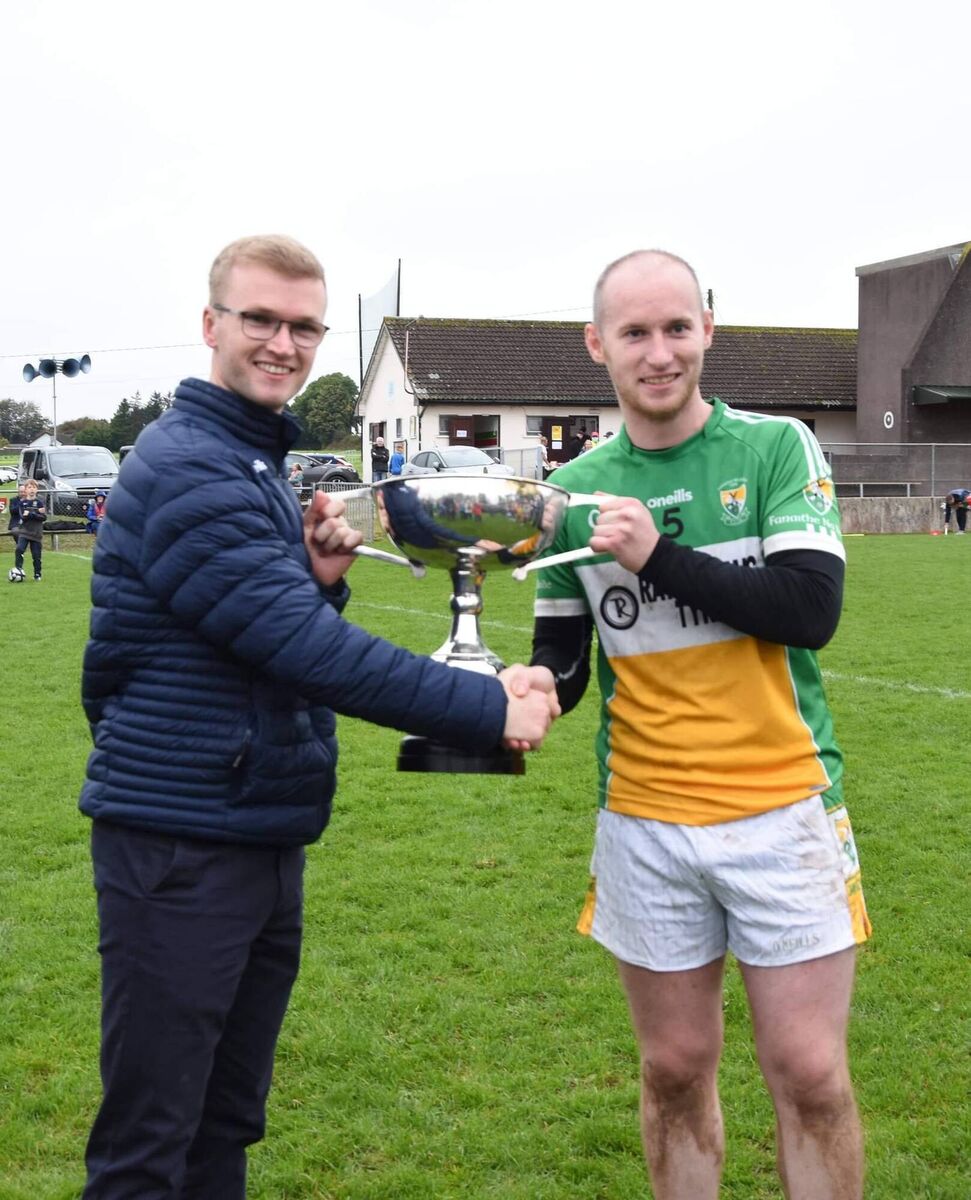 Imokilly GAA Board Secretary Daniel Lane presents the Jim Ryan Memorial Cup to Bride Rovers team captain Jason Mannix. 