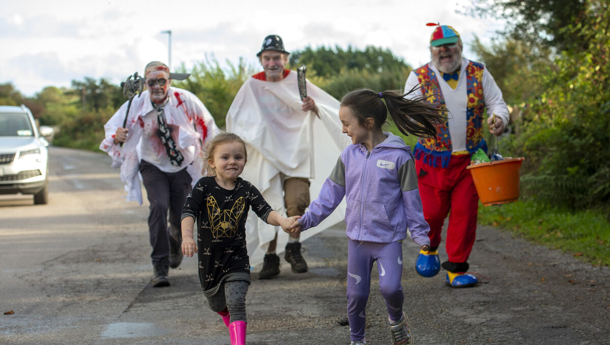  Ava and Ellie Sweeney running for their lives from Cork's oldest trick-or-treaters John A. Murphy, Martin Murphy and Con Prout who have been trick-or-treating together for decades in Crossbarry, Co Cork. Picture Dan Linehan