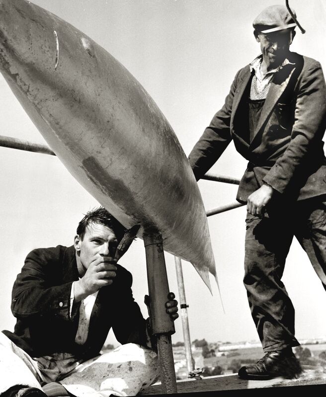 Corporation painter Tom Holmes (left) helped by Michael O'Sullivan seen here 193 feet high on Cork's Shandon Steeple gilding the fish at the top of Shandon steeple with laminated gold in August 1959.