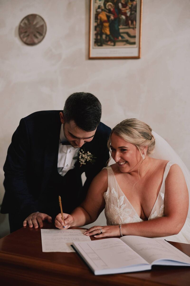 The couple signing the register. The couple signing the register.
