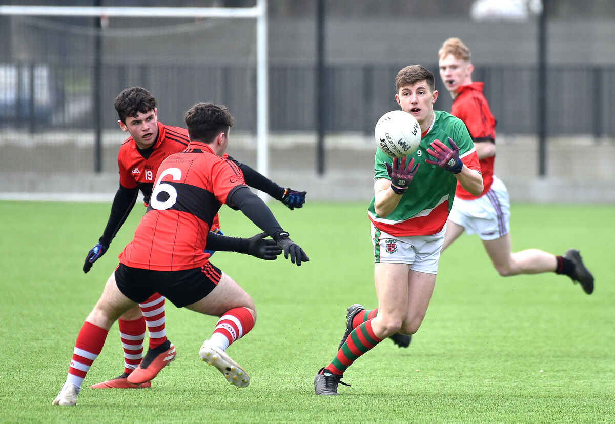  Conor Corbett, Patrician Academy, getting his pass past Nathan Gough, Coláiste an Spiorad Naomih. Picture Dan Linehan