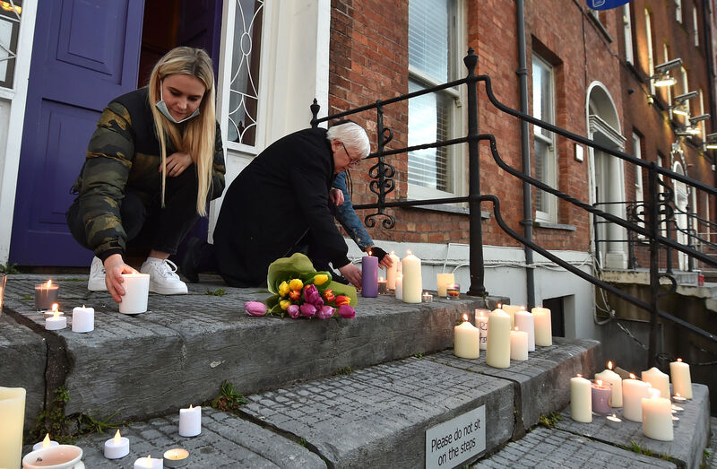  Aisling McEveney, Mary Crilly and Sola Twomey light candles and lay flowers at a candlelight vigil. Picture Dan Linehan
