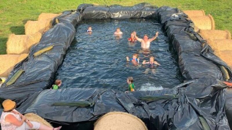 Farmer swimming in hay with makeshift pool