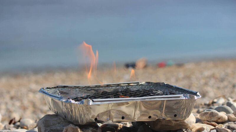 Fire service dealing with plastic bins on fire due to unquenched disposable barbecues
