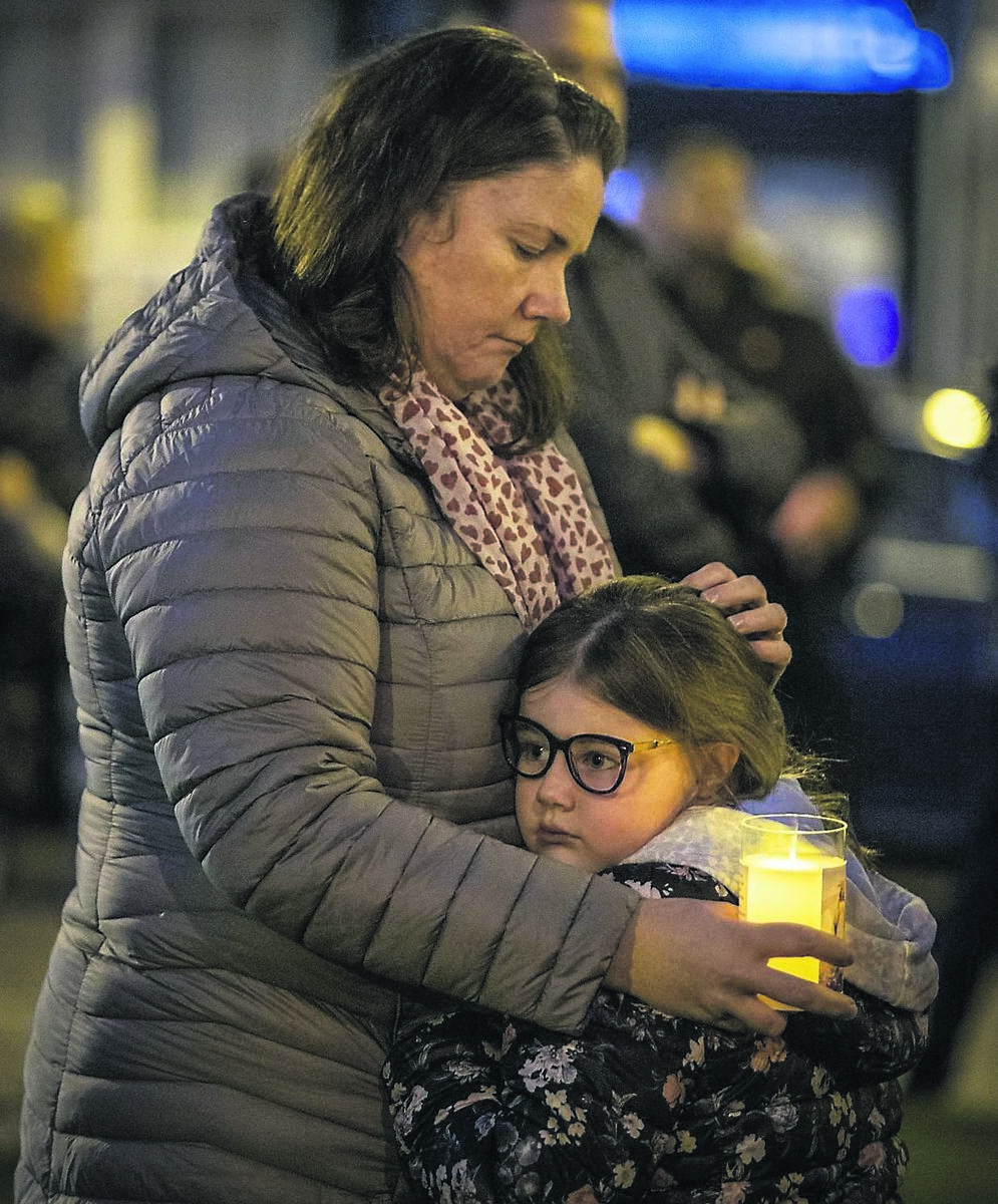 Louise Gallen holds her 6-year-old daughter Mollie during a moment of silence in Castlefinn, Co Donegal, for victims of Creeslough
