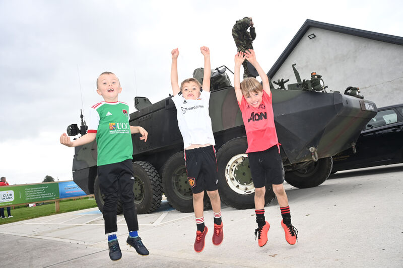  Young players James O'Callaghan, James Flynn and Cillain Prendiville beside an army mowag at the family fun day. Pic: Larry Cummins.