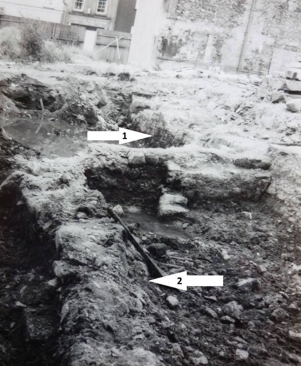 Image showing the base of Hopewell Castle from Christ Church Lane. This photograph is one of only two images, both taken by Richard T. Cooke in August 1984, capturing this historic structure for posterity just hours before it was inadvertently levelled. Arrow 1 points to the city wall and Arrow 2 points to the base of Hopewell Castle. Image showing the base of Hopewell Castle from Christ Church Lane. This photograph is one of only two images, both taken by Richard T. Cooke in August 1984, capturing this historic structure for posterity just hours before it was inadvertently levelled. Arrow 1 points to the city wall and Arrow 2 points to the base of Hopewell Castle.