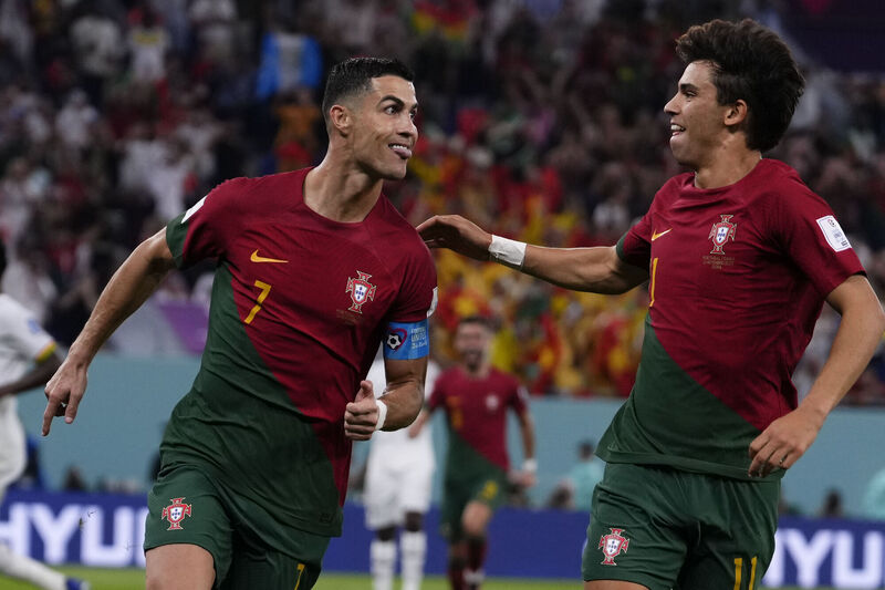 Portugal's Cristiano Ronaldo, left, celebrates with teammate Joao Felix after scoring from the penalty spot his side's opening goal against Ghana during a World Cup group H soccer match at the Stadium 974 in Doha, Qatar, on Thursday. Picture: AP Photo/Manu Fernandez