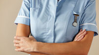 UK nurse standing with arms folded