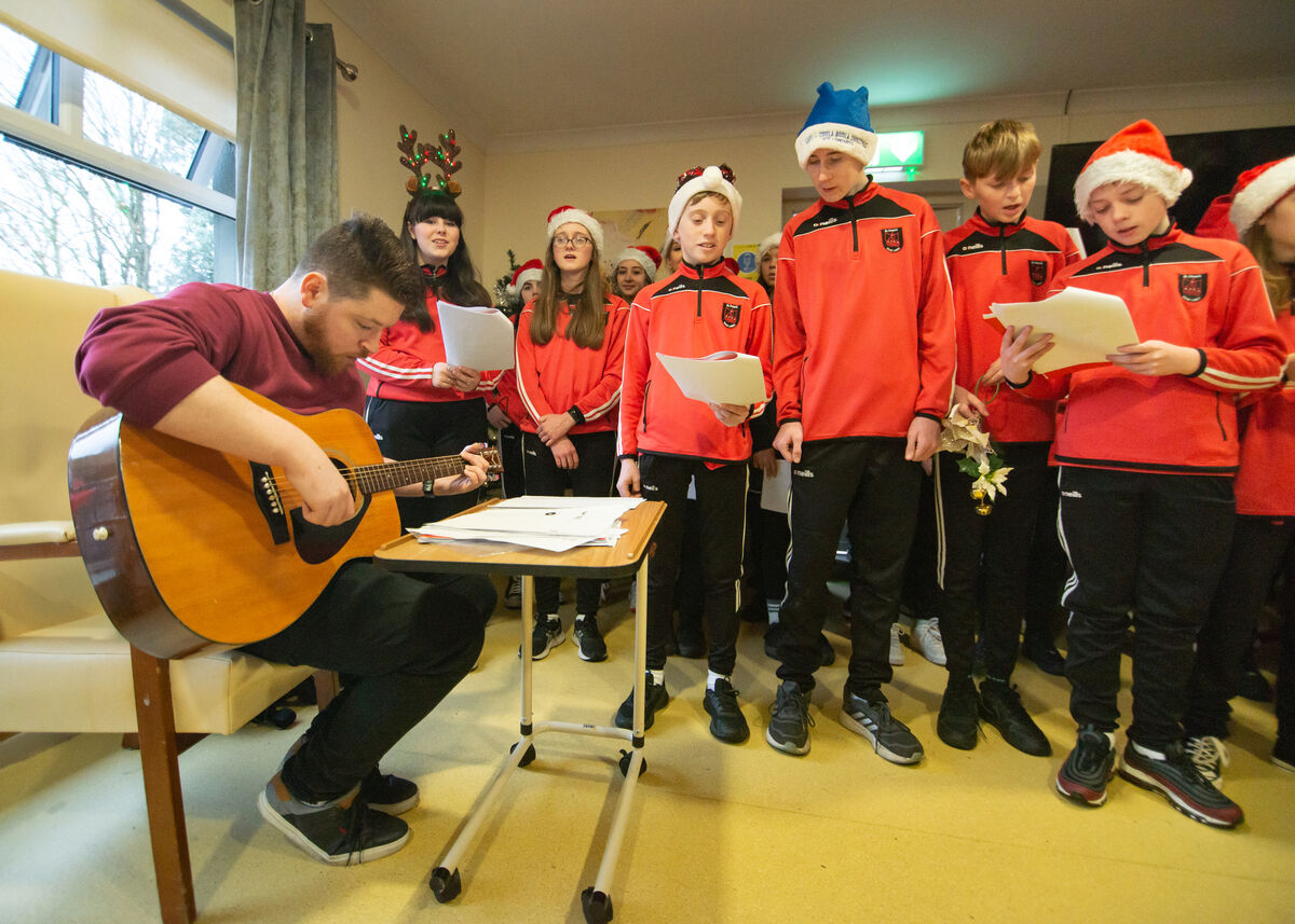 First, second, and fifth year students from St Peter's Community School, Passage West, sing Christmas songs accompanied by teacher, Alan Murphy, for the residents and staff of Padre Pio Nursing Home in Rochestown. Picture: Cian O'Regan.