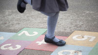 UK schoolgirl playing hopscotch in the playground of a UK primary school