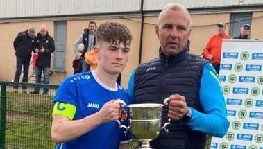 Evan Bolster captain of the Midleton AFC U18 team accepting the Munster Youth Cup. 
