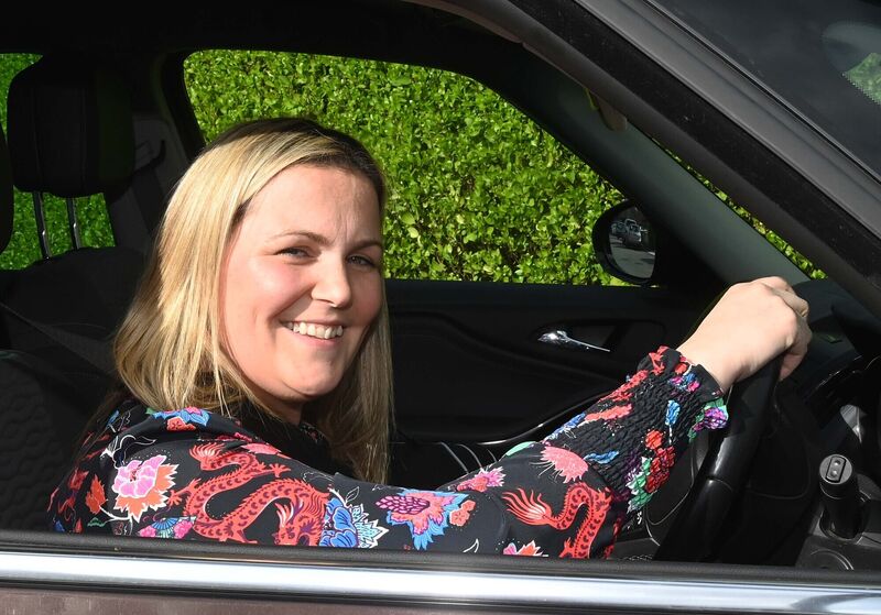 Behind the wheel of her car.