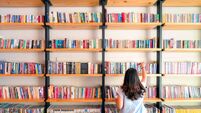 Asian women are picking up books on the bookshelf. To prepare to back to school