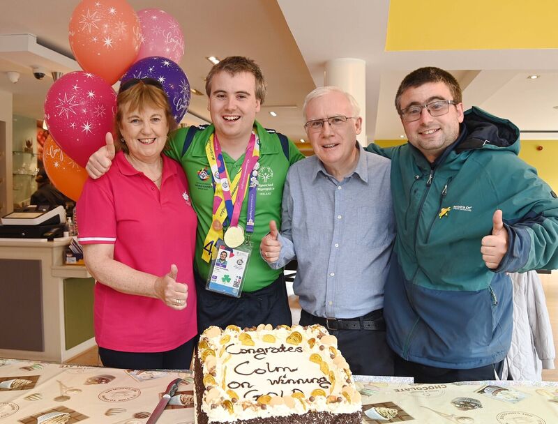 Colm Monahan, a member of the staff at Chapel Gate Café, Ballincollig, run by the Brothers of Charity, during a celebration in his honour in the café on his return with a men's singles gold medal for badminton at the Special Olympics World Games, pictured with his parents Bríd and Pat and his brother Fearghal. Colm Monahan, a member of the staff at Chapel Gate Café, Ballincollig, run by the Brothers of Charity, during a celebration in his honour in the café on his return with a men's singles gold medal for badminton at the Special Olympics World Games, pictured with his parents Bríd and Pat and his brother Fearghal.
