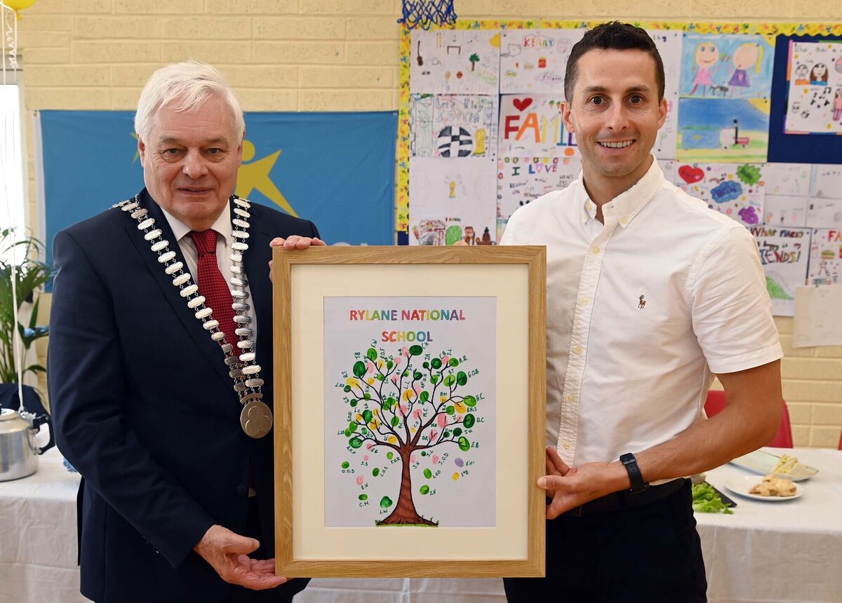 Cllr. Frank O'Flynn, Mayor of the County of Cork, who officially opened Rylane National School garden, being presented with a framed leaf fingerprint of all the pupils by Brian Reidy, principal, to mark the occasion. Picture Denis Minihane.