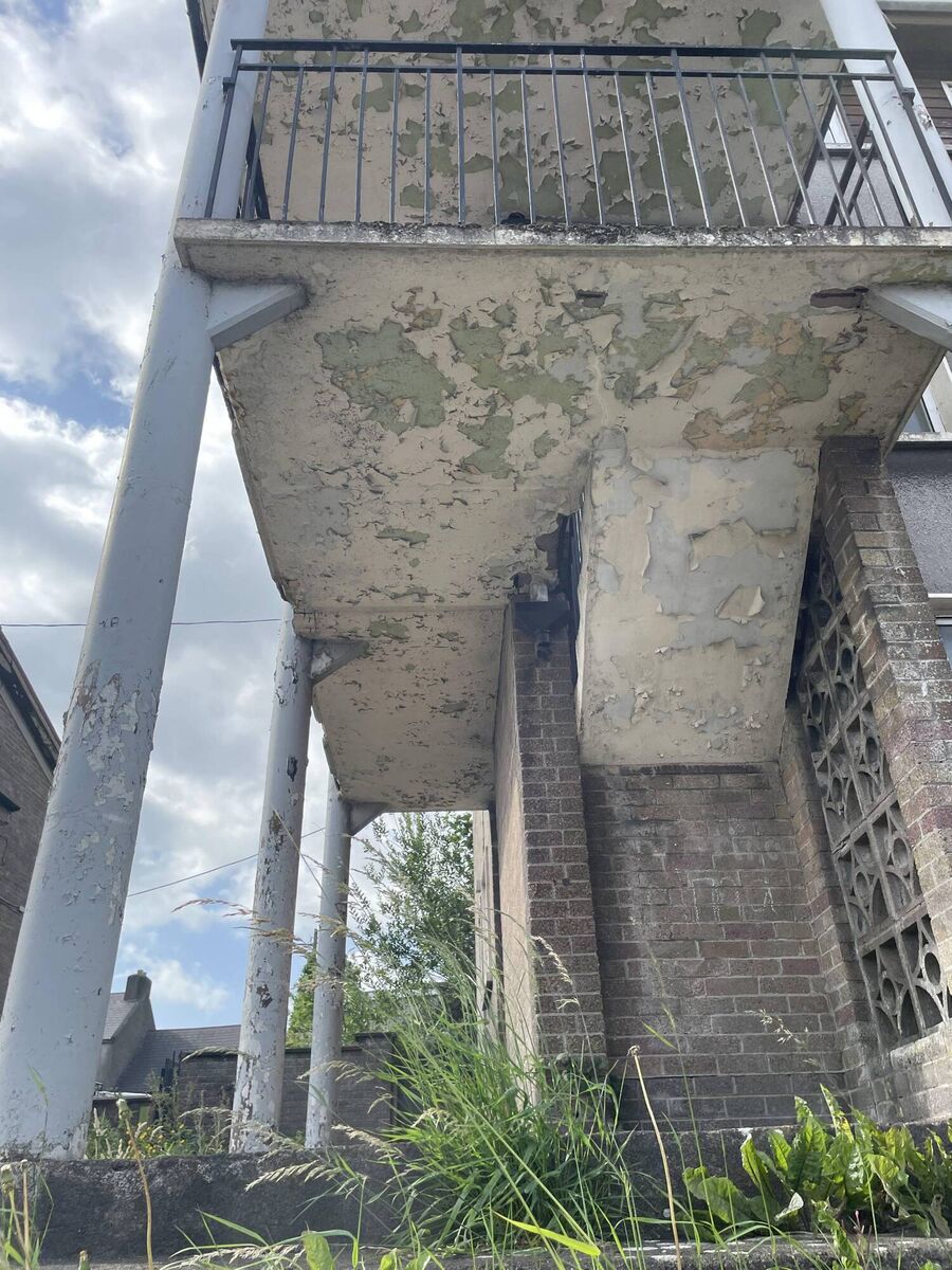 Weeds grow beneath one of the stairwells of the Noonan's Road flats. Picture: Donal O'Keeffe.