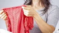 caucasian woman folding clothes after laundry