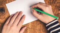 Woman writing recipient address on mailing envelope