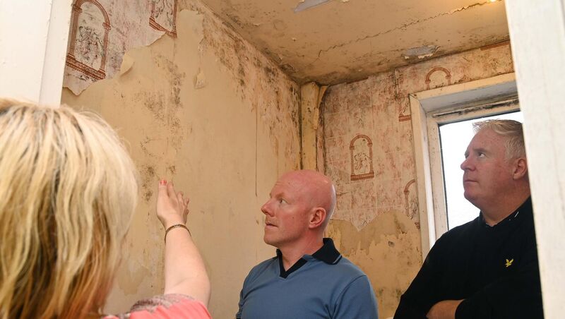 A tenant pointing out the mould and water damage from leaks in the bathroom in a flat at Noonan (Noonan's) Road, Cork, to Cllr Mick Finn (right) and William O'Brien.