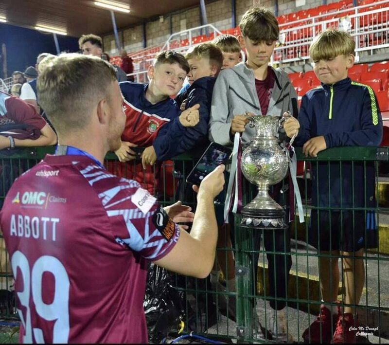 Jason Abbott giving the Munster Senior Cup to some Cobh Ramblers fans, and taking a picture of them with it. Picture: Instagram/cobhramblersfc Jason Abbott giving the Munster Senior Cup to some Cobh Ramblers fans, and taking a picture of them with it. Picture: Instagram/cobhramblersfc