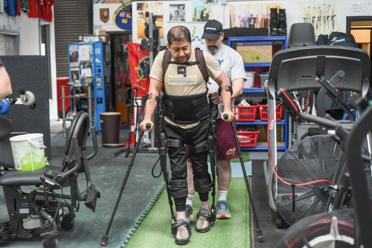 Assisted by Colin O'Shaughnessy, Ahmad is pictured using a robotic exoskeleton to walk during a rehabilitation session at Elite Fitness Cork, Marina Commercial Park. Picture: Cian O'Regan. Assisted by Colin O'Shaughnessy, Ahmad is pictured using a robotic exoskeleton to walk during a rehabilitation session at Elite Fitness Cork, Marina Commercial Park. Picture: Cian O'Regan.