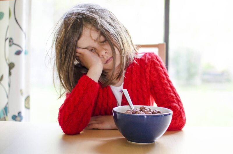 A tired child sleeps at the breakfast table. A tired child sleeps at the breakfast table.