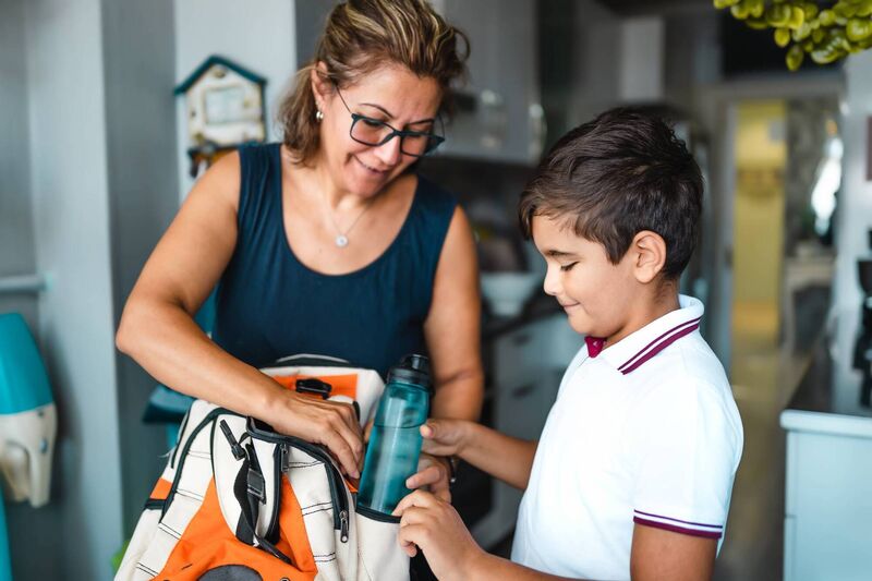 A mother helping her son get ready for school A mother helping her son get ready for school