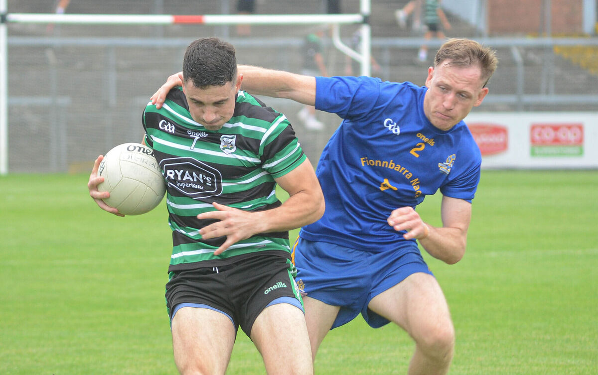 Sean Wilson of Douglas manages to keep the ball away from Sam Ryan of St Finbarrs. Picture: Howard Crowdy Sean Wilson of Douglas manages to keep the ball away from Sam Ryan of St Finbarrs. Picture: Howard Crowdy