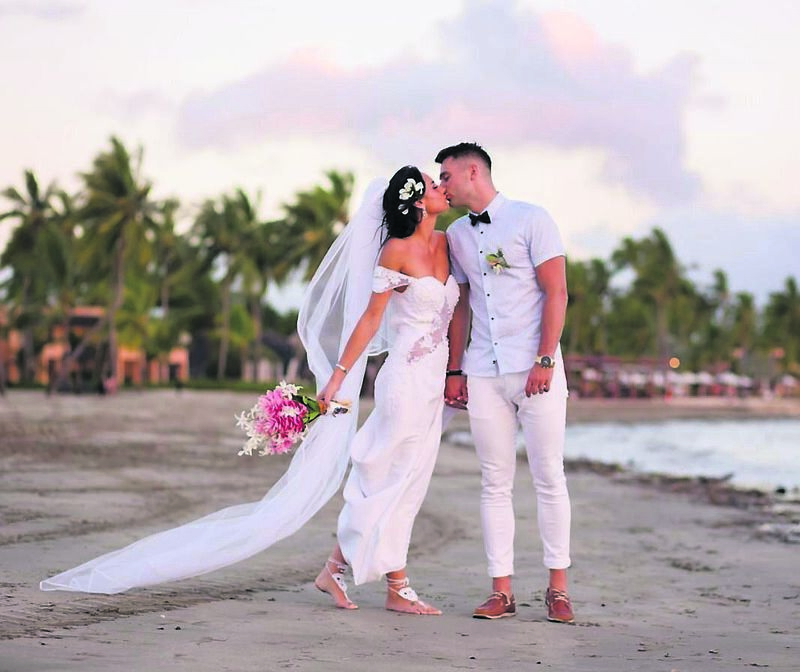 Former Miss Cork Étaoin Ní Ailpín and Neil Waters kiss on the beach on their wedding day.