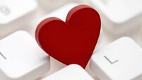 Small red heart on computer keyboard. Internet dating concept.
