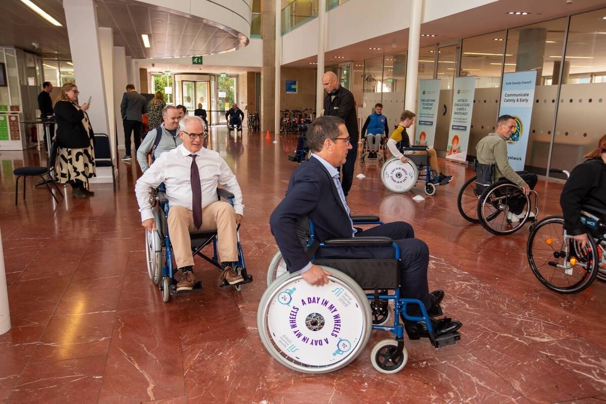  CEO of Cork Chamber Conor Healy, SII Corporate Business Development Lead Dan Kiely and other attendees taking part in a wheelchair skills course at A Day In My Wheels event.
