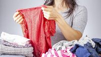 caucasian woman folding clothes after laundry
