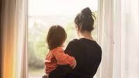 Mother and son looking out of window