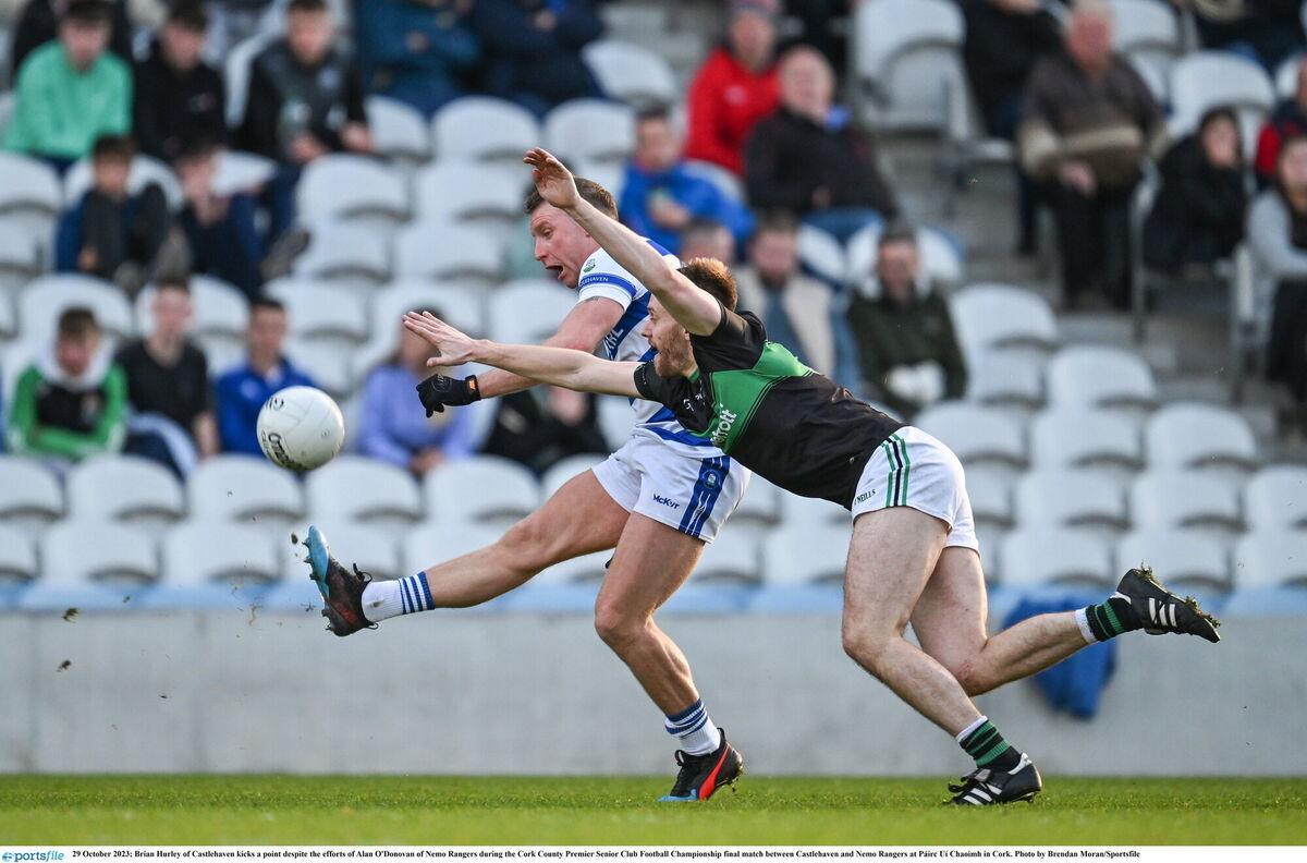 Brian Hurley of Castlehaven kicks a point despite the efforts of Alan O'Donovan of Nemo Rangers. Photo by Brendan Moran/Sportsfile