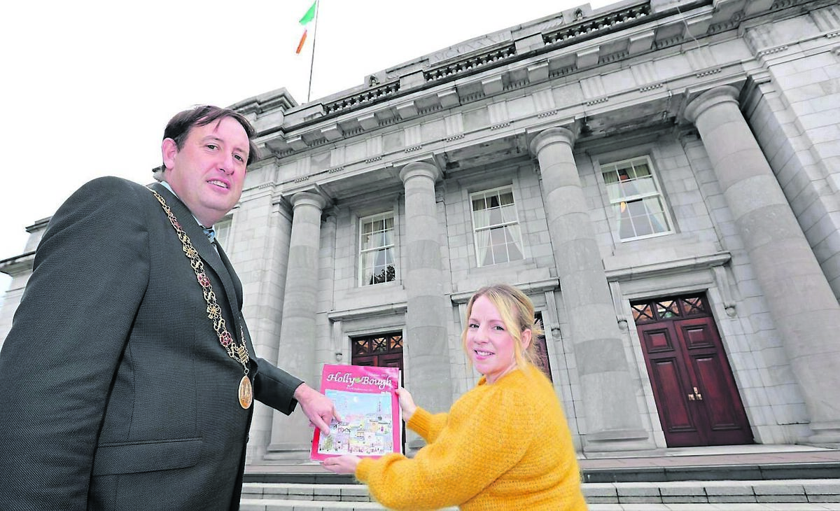 Pointing out the City Hall on the cover of the 2023 Holly Bough is Lord Mayor Cllr Kieran McCarthy with Fiona Foley, Illustrator from Toames Macroom Co. Cork. Picture: Jim Coughlan. Pointing out the City Hall on the cover of the 2023 Holly Bough is Lord Mayor Cllr Kieran McCarthy with Fiona Foley, Illustrator from Toames Macroom Co. Cork. Picture: Jim Coughlan.
