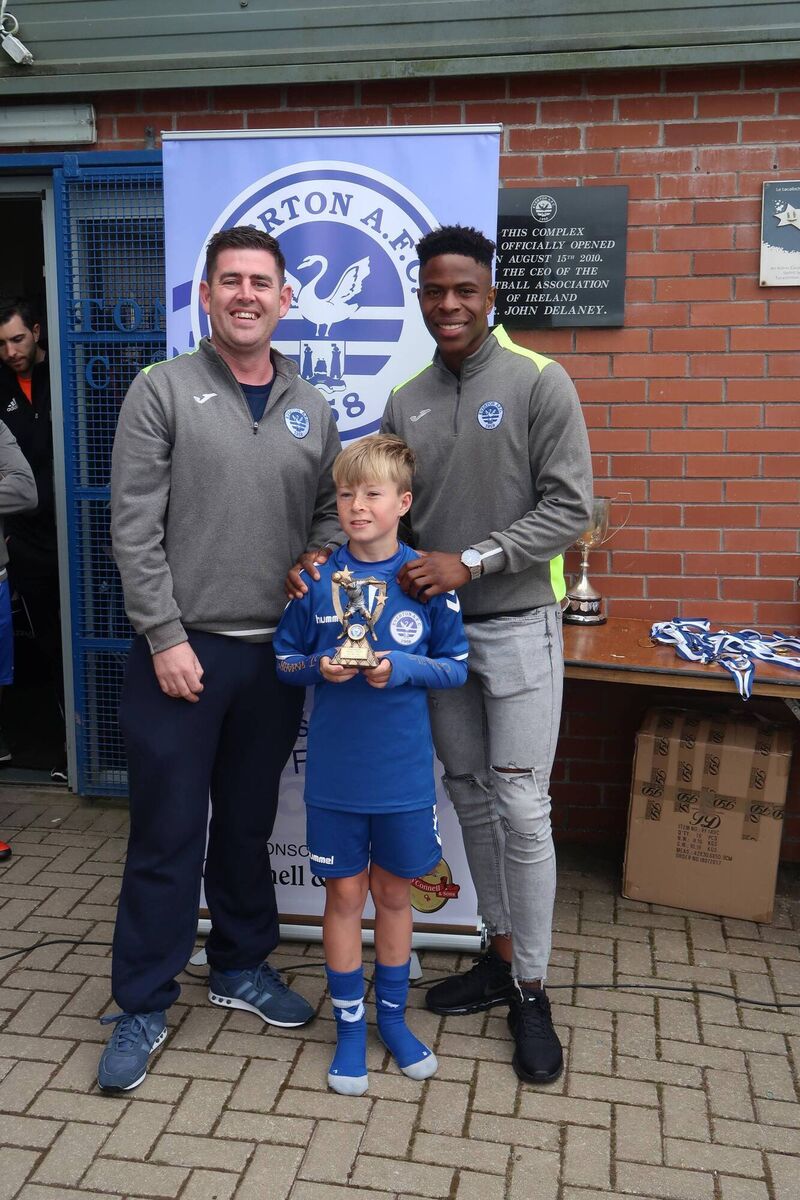 U11 manager Keith Gahan and former Everton youth player Chiedozie Ogbene present Dylan McCarthy with the Players Player of the Year award.