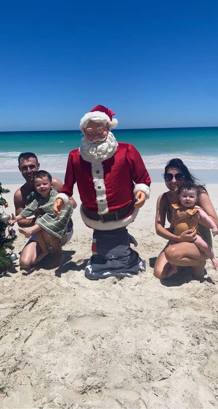 John Carmody and Rebecca with their kids at Christmas on the beach. 
