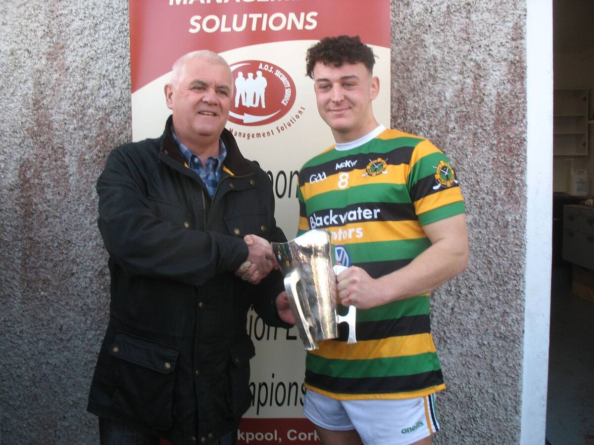 Seandún chairman Michael Higgins presenting the AOS Security Mangement Solutions Seandún U21 B Hurling trophy to Glen Rovers captain David O'Callaghan.