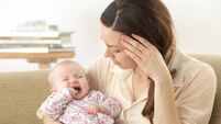 Concerned Mother With Upset Baby Teething