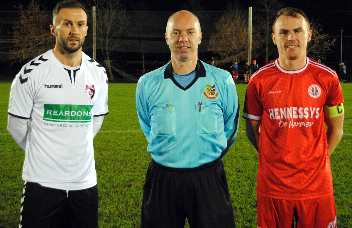City Wanderers captain Eric Marah (left) with Village United's Anthony Kiniry, accompanied by referee Grahame Duffy.