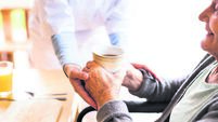Unrecognizable health visitor and a senior woman during home visit.